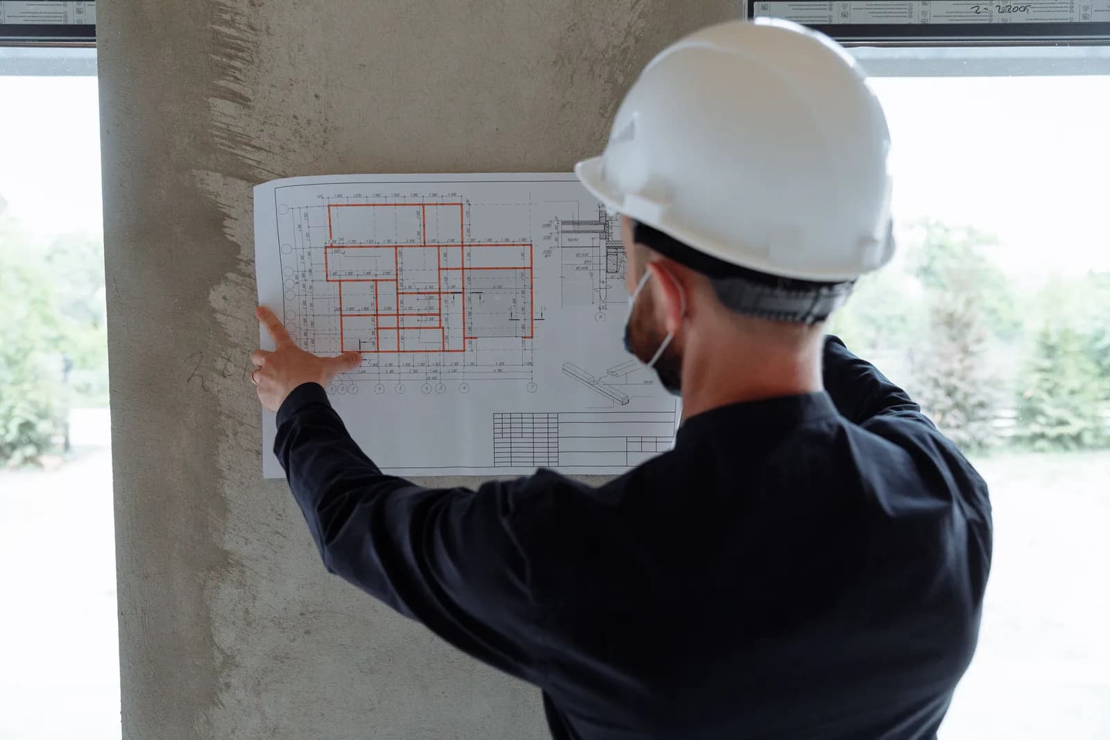 建設現場で図面を確認する施工管理技術者の様子