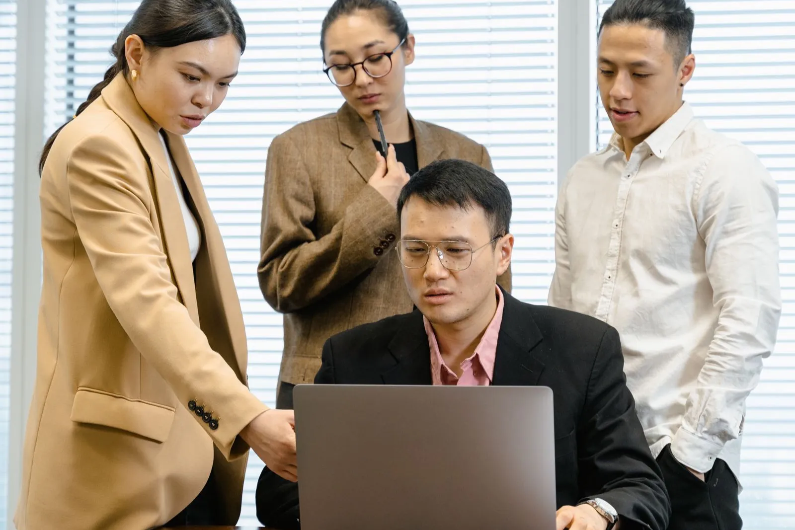 複数の紹介会社からの推薦を一覧表にまとめた画面を見ながら打ち合わせをする採用チーム